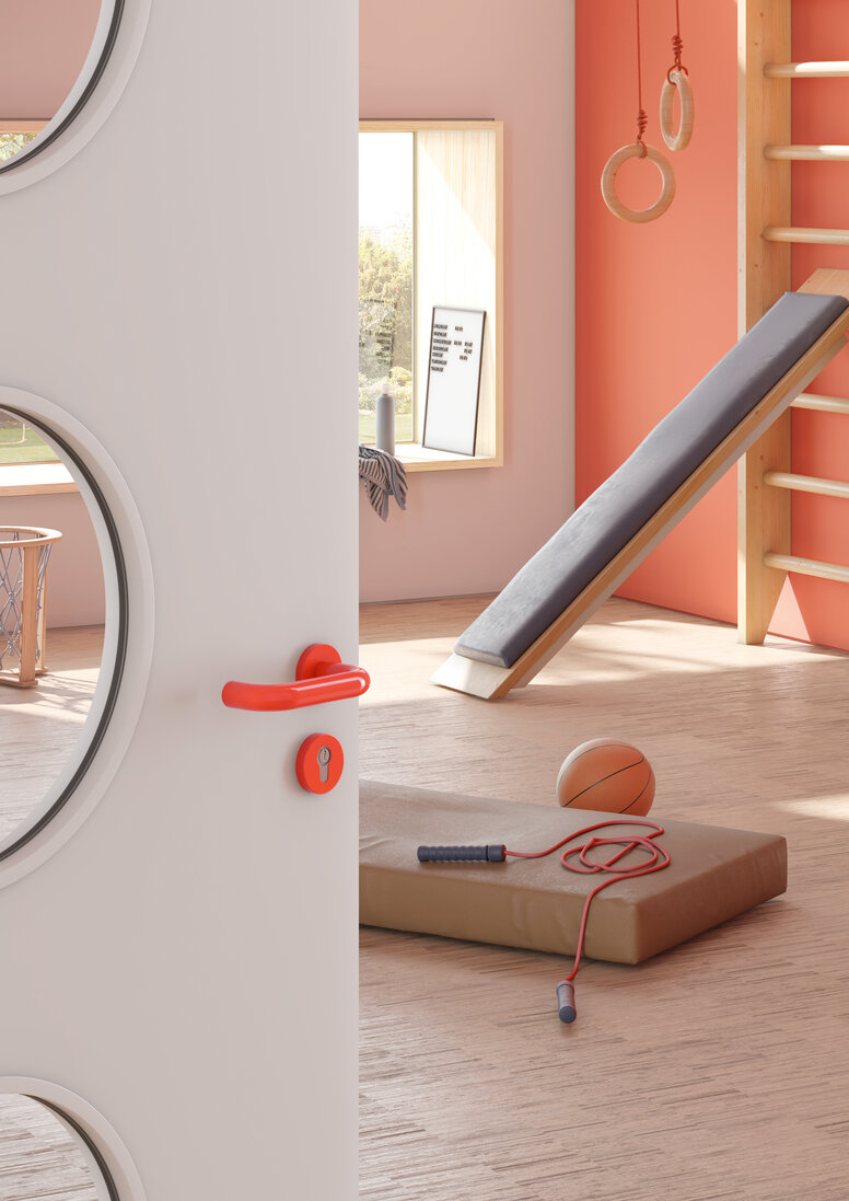 Door to a sports room of a kindergarten equipped with a lever handle in the colour orange made of polyamide