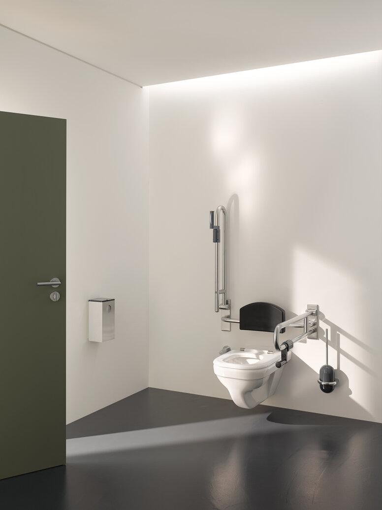 Barrier-free WC in public areas equipped with folding support handles, back support and WC brush