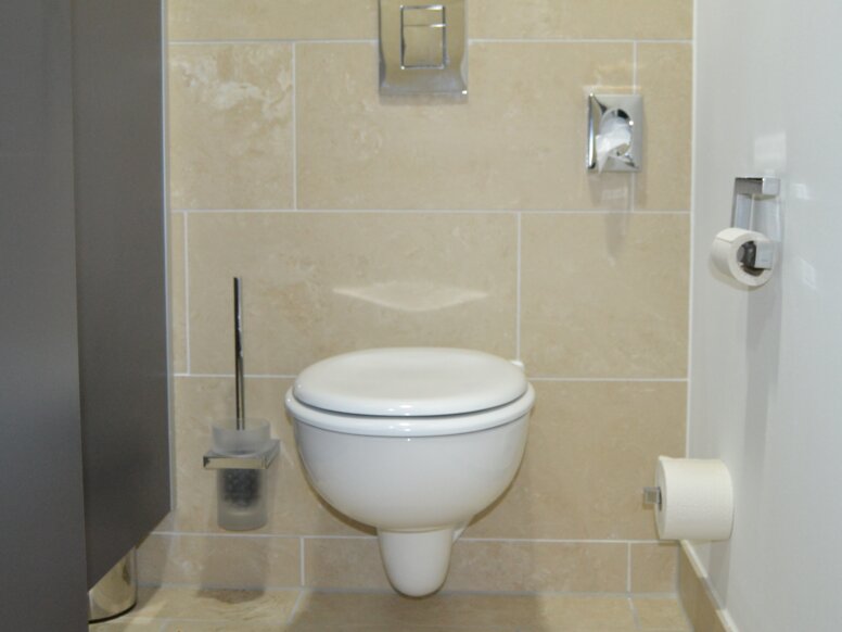 Toilet equipped with System 100, toilet brush set, paper holder, spare paper holder, sanitary bag dispenser