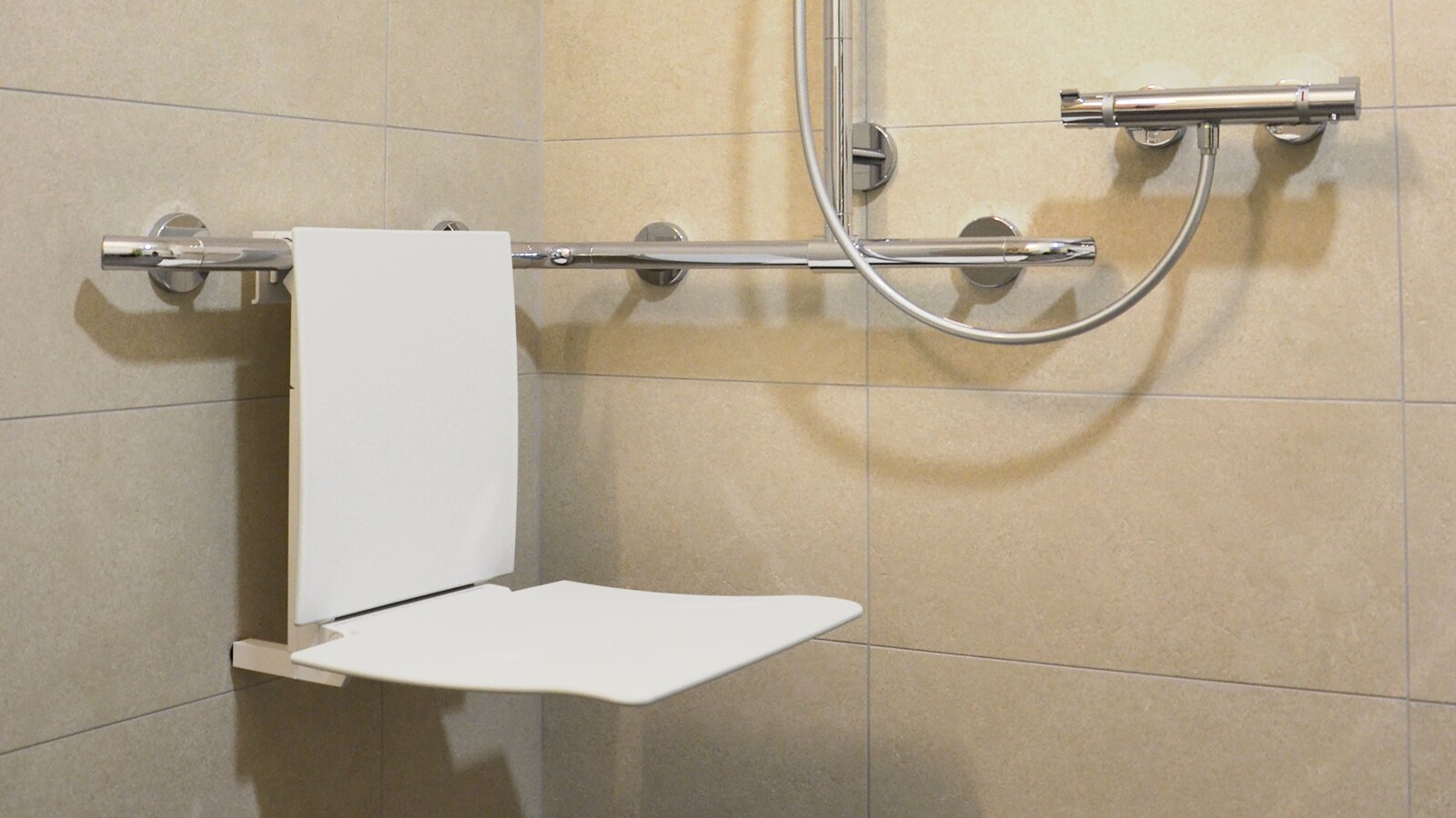 Shower with hanging seat and shower handrail