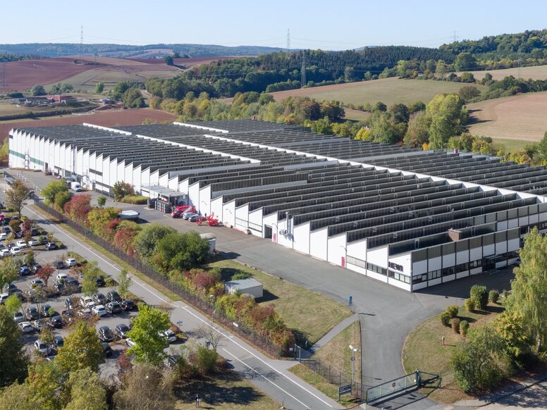 Dronebeeld van de HEWI-fabriek met witte gevel